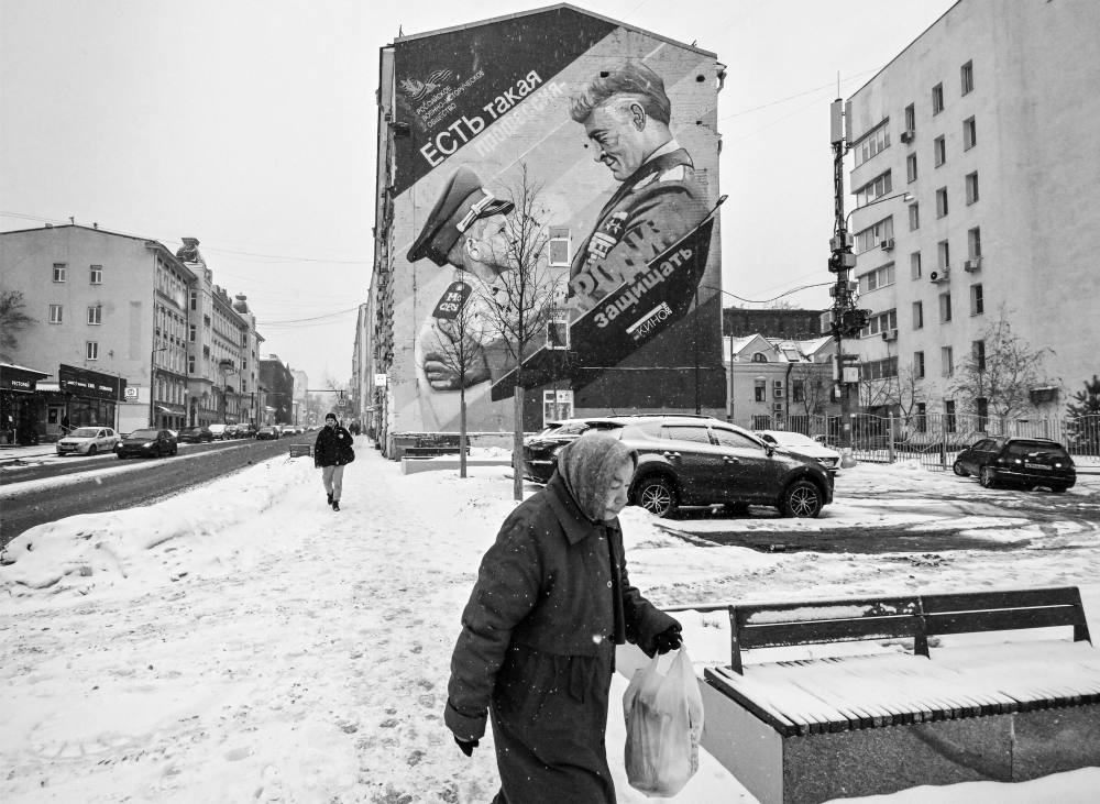 A lady walks down a snowy street