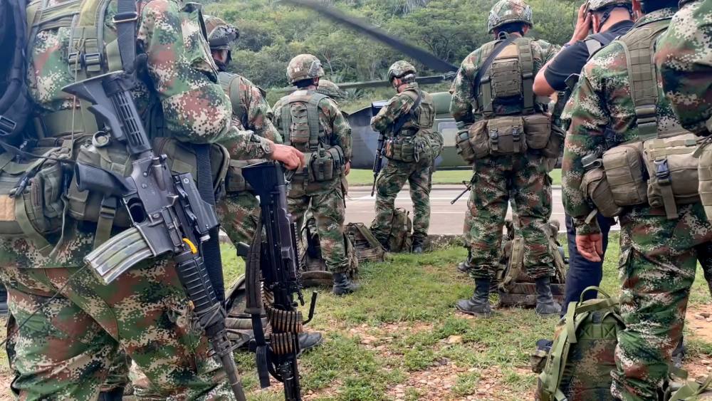 Colombian soldiers gathered outside of a helicopter.
