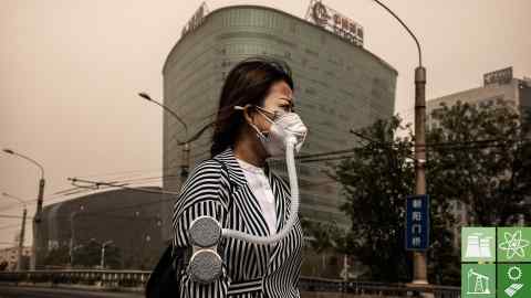 BEIJING, CHINA - MAY 04: A Chinese woman wears a mask to protect from particles blown in during a sandstorm as she walks in the street on May 4, 2017 in Beijing, China. Sandstorms are common in northern China during the spring season and are caused when heavy winds from Mongolia in the north brings sand and pollutants that can blanket Chinese cities and cause air quality to deteriorate. (Photo by Kevin Frayer/Getty Images)