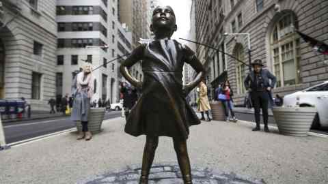 A statue of a defiant girl stands facing the Charging Bull sculpture in the Financial District of New York, U.S., on Wednesday, March 8, 2017. State Street Global Advisors, a nearly $2.5 trillion investor and unit within State Street Corp., installed the bronze statue in front of Wall Street's iconic charging bull as part of its new campaign to pressure companies to add more women to their boards. Photographer: Jeenah Moon/Bloomberg