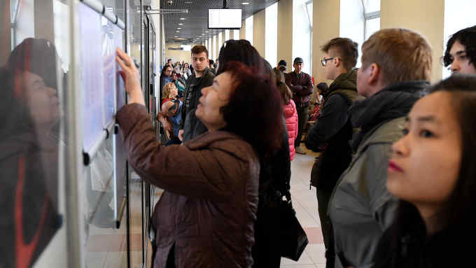 People look at a notice board at the regional department of foreigners' affairs where foreigners can get work and residency permits in central Warsaw on April 26, 2018. - To keep its economy growing, Poland is banking on workers from abroad. (Photo by JANEK SKARZYNSKI / AFP) / TO GO WITH AFP STORY by Michel VIATTEAU (Photo credit should read JANEK SKARZYNSKI/AFP/Getty Images)