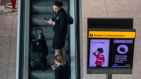 © Licensed to London News Pictures. 10/03/2020. London, UK. Flight attendants arrive at a quiet Terminal 5 as British Airways cancels all flights to and from Italy over fears of the Coronavirus disease. Photo credit: Alex Lentati/LNP