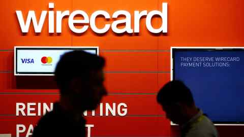 People walk past the Wirecard booth at the computer games fair Gamescom in Cologne, Germany, August 22, 2018. REUTERS/Wolfgang Rattay - RC15E3B46DE0