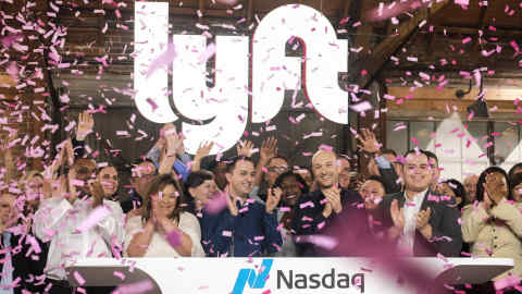 Lyft co-founders John Zimmer, front third from left, and Logan Green, front third from right, cheer as they as they ring a ceremonial opening bell in Los Angeles, Friday, March 29, 2019. On Friday the San Francisco company's stock will begin trading on the Nasdaq exchange under the ticker symbol "LYFT." (AP Photo/Ringo H.W. Chiu)