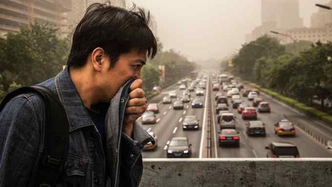 BEIJING, CHINA - MAY 04: A Chinese man covers his mouth and nose with his jacket to try and protect from particles blown in during a sandstorm as he walks in the street on May 4, 2017 in Beijing, China. Sandstorms are common in northern China during the spring season and are caused when heavy winds from Mongolia in the north brings sand and pollutants that can blanket Chinese cities and cause air quality to deteriorate. (Photo by Kevin Frayer/Getty Images)