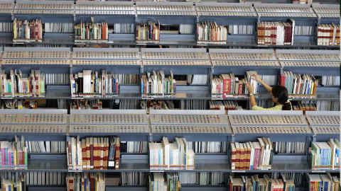 A visitor checks through a shelf for books at the newly built Singapore's National Library