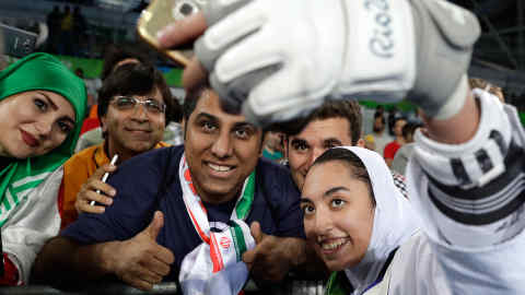 Kimia Alizadeh Zenoorin of Iran takes a selfie photo with spectators as she celebrates after winning the bronze medal in a women's Taekwondo 57-kgcompetition at the 2016 Summer Olympics in Rio de Janeiro, Brazil, Thursday, Aug. 18, 2016. (AP Photo/Andrew Medichini)