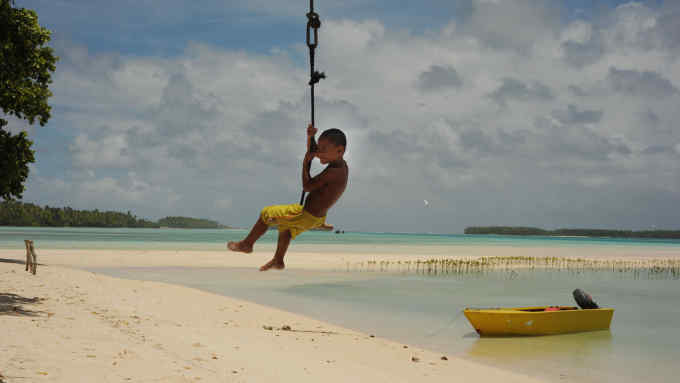 A child plays on the island of Funafala which is an islet of Funafuti, Tuvalu. Funafula has small community with a population of about 14 inhabitants. Mangoves have been planted to protect the costal areas and to encourage marine life.The low lying islands of Tuvalu are extremely vulnerable to climate change with sea levels rising. With the threat of tropical storms the islands only source of communication with other islands is through radio contact. . The highest level of elevation is 4.6 metres above Sea Level. Â© Annabel Cook