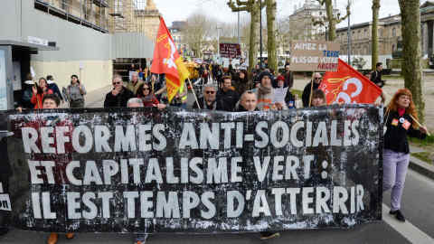 Protesters hold a banner reading "anti-social reforms and green capitalism: it's time to land" during a demonstration for climate change in Bordeaux, despite the authorities' recommendations to limit gatherings amid the outbreak of COVID-19, caused by the novel coronavirus, on March 14, 2020. (Photo by MEHDI FEDOUACH / AFP) (Photo by MEHDI FEDOUACH/AFP via Getty Images)
