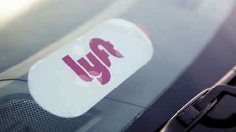 A Lyft Inc. decal is displayed on a car window in Los Angeles, California, U.S., on Monday, Nov. 13, 2017. Lyft Inc. has gained significant ground on its rival, Uber Technologies Inc., and is expected to grab more market share in the U.S., according to a private Lyft investor document obtained by Bloomberg. Photographer: Patrick T. Fallon/Bloomberg