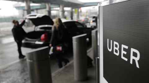 FILE - In this March 15, 2017, file photo, a sign marks a pick up point for the Uber car service at LaGuardia Airport in New York. Startup SURE says it has partnered with underwriter Chubb to launch a new service that allows Uber and Lyft ride-hailing passengers to buy accidental medical, death and dismemberment insurance coverage for the ride. The program, called RideSafe, works by connecting a customer's Uber or Lyft account to their SURE Insurance app, and once coverage is initially authorized, the passenger's ride is automatically insured. (AP Photo/Seth Wenig, File)