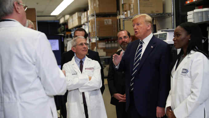U.S. President Donald Trump is flanked by Director of National Institute of Allergy and Infectious Diseases Anthony Fauci; Health and Human Services (HHS) Secretary Alex Azar; and National Institutes of Health Doctor Dr Kizzmekia Corbett, research fellow at the NIH Vaccine Research Center, as he listens to Doctor Barney Graham, deputy director of the National Institute of Allergy and Infectious Diseases, following a briefing at the Vaccine Research Center in Bethesda, Maryland, U.S., March 3, 2020. REUTERS/Leah Millis