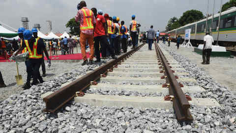 Workers stand along a prototype rail line, to be constructed by China Railway Construction Corporation (CRCC), during the ground breaking for the construction of Lagos-Ibadan rail line project at the Ebute-Metta headquarters of the Nigerian Railway Corporation in Lagos on March 7, 2017. Nigeria's acting President Yemi Osinbajo has signed off on the construction of the Lagos-Ibadan double track railway line modernisation project to be executed by the China Railway Construction Corporation (CRCC). The project, when completed, will open up direct transit from the coastal city of Lagos, Nigeria's commercial capital, to Ibadan, in the heart of the south west. / AFP PHOTO / PIUS UTOMI EKPEI (Photo credit should read PIUS UTOMI EKPEI/AFP/Getty Images)