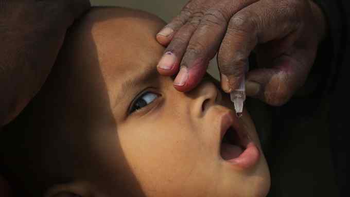 FILE - In this Dec. 11, 2018 file photo, a Pakistani health worker gives a polio vaccination to a child in Karachi, Pakistan. Pakistani officials said, Wednesday, Jan. 9, 2019 that the country is on track to eradicate polio in 2019 despite Taliban attacks and superstition that has spurred many parents in the region bordering Afghanistan to refuse to vaccinate their children against the crippling disease. (AP Photo/Shakil Adil, File)