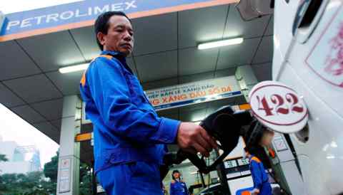 A man pumps gasoline at a gas station in Hanoi, run by Vietnam's top fuel importer and distributor Petrolimex.
