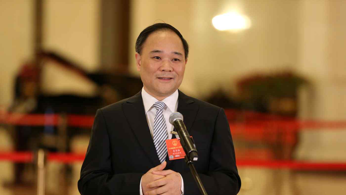 Geely Chairman Li Shufu talks to the media before the closing session of the National People's Congress, which he attended as a delegate, at the Great Hall of the People in Beijing on March 20.