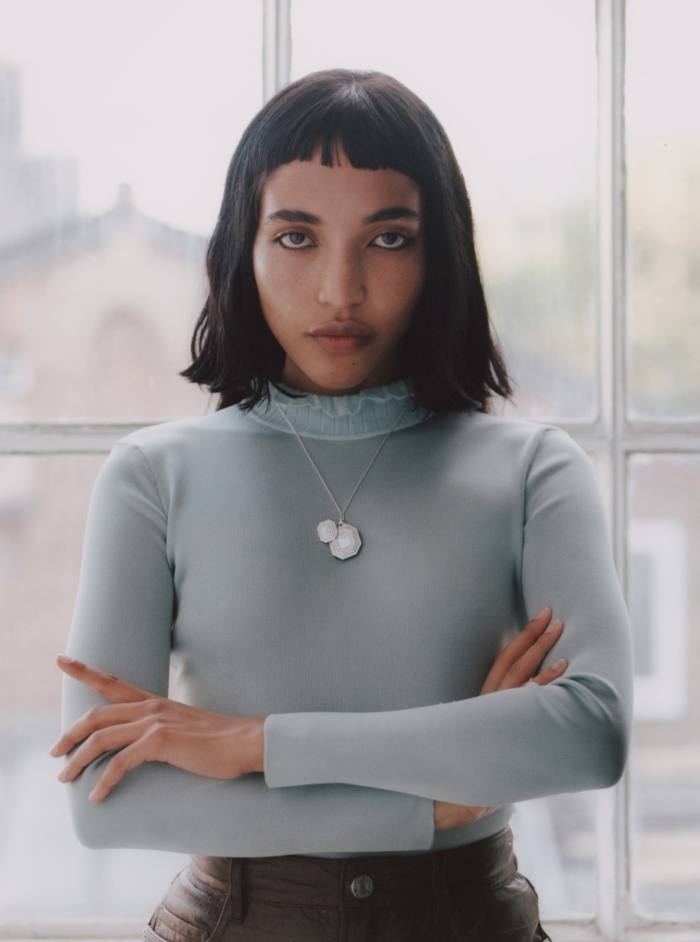 Akima wears a Harry Winston white gold and diamond Emerald Signature secret watch (worn on the wrist, as a pendant or as a brooch), POA.  Hermès silk knit sweater, £1,000.  Frame leather skirt, €1,099