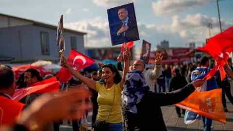 Supporters of Recep Tayyip Erdoğan dance as they hand out presents to commuters in Istanbul