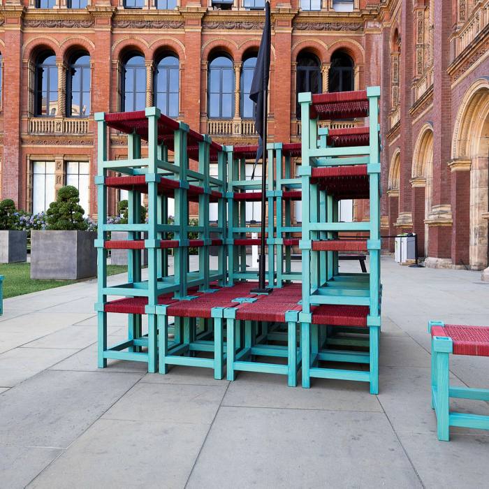 A large hollow cube made up of stools stacked on top of each other