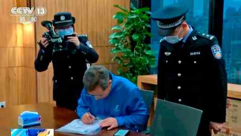 En esta imagen de un video sin fecha emitido por CCTV de China, la policía china hace trabajo de aplicación de la ley mientras allana la oficina de Capvision en Shanghái.