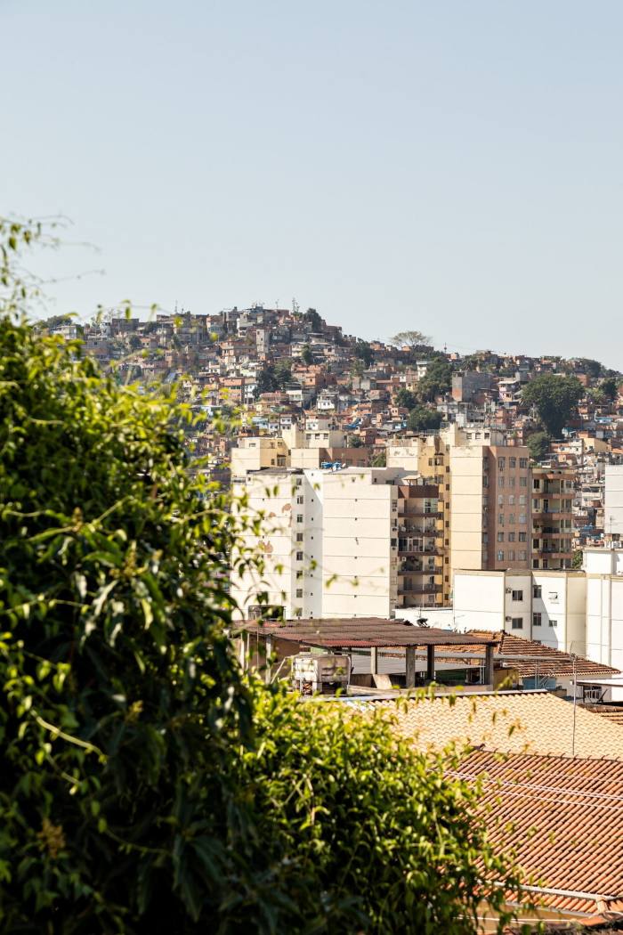     Photograph of a hilly urban landscape with sloping terracotta rooftops and apartment blocks