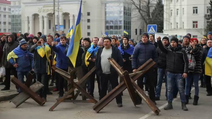 المتظاهرون يصرخون على الجنود الروس خلال مسيرة مؤيدة لأوكرانيا في خيرسون في مارس.  وتلاشت الاحتجاجات منذ ذلك الحين بعد أن فرقتها القوات بالقوة 