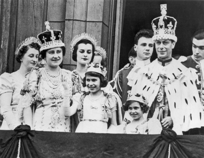 Princess Elizabeth, waving, with the royal family dressed in ermine and crowns, on the balcony of Buckingham Palace following the coronation King George VI in 1937 