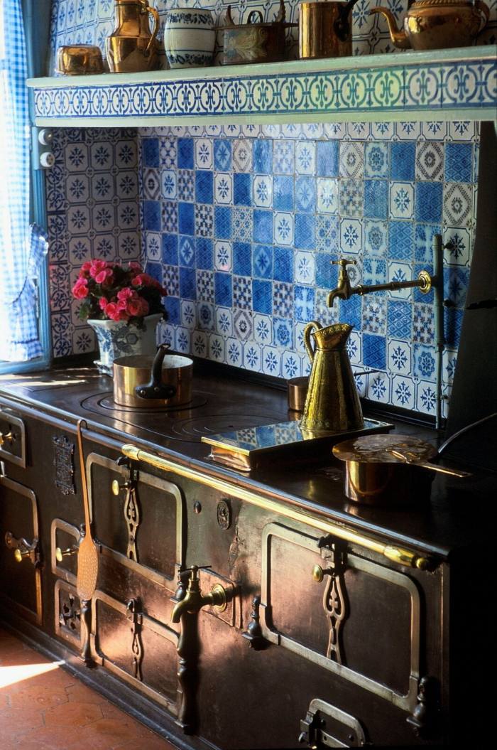 Claude Monet’s kitchen in Giverny, France, with blue and white tiles in various patterns along the walls