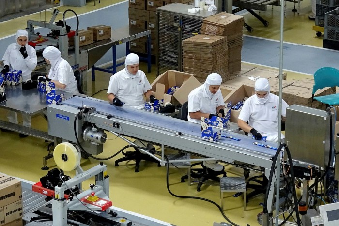 Empleados de la Fábrica Nacional de Chocolate, empresa del Grupo Nutresa, trabajan en una empacadora en Medellín, Colombia, el 25 de junio de 2019.