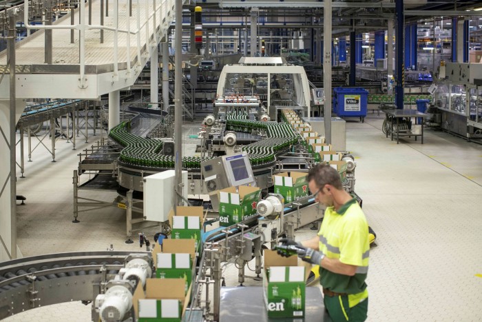 An employee carries out quality checks as Heineken beer bottles move along a packaging conveyor at the Heineken brewery in the Netherlands. The pandemic forced Heineken to rethink its strategy of producing regional brands locally and then exporting them to bigger markets