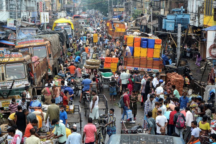 People shop at a wholesale vegetable market in Kolkata