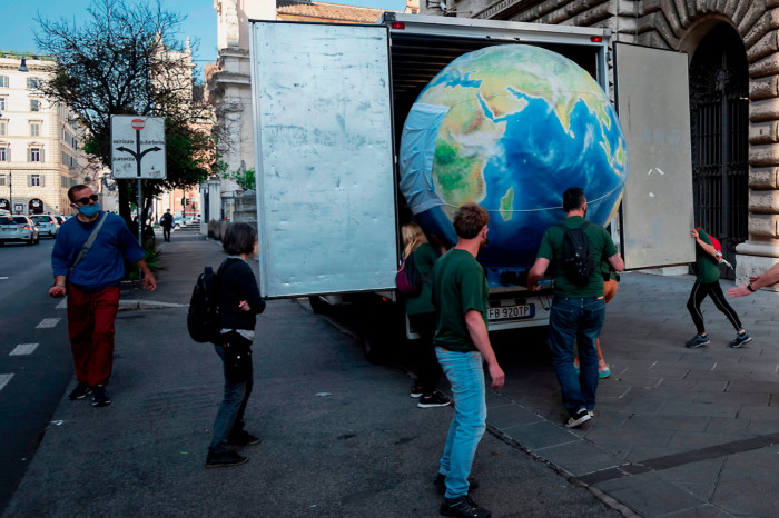 Activists unload a model of a sick planet Earth from a van