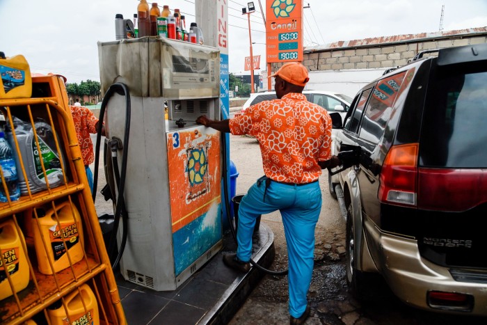 Un asistente dispensa gasolina en el tanque de un vehículo en una estación en Lagos.
