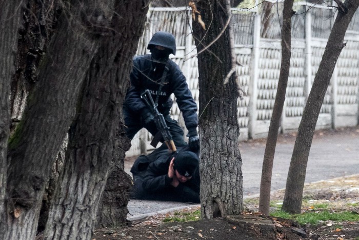 A Kazakh riot policeman detains a protester in Almaty