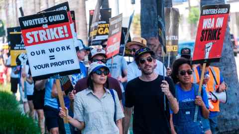 Striking writers and actors march with sit-downs outside Sunset Bronson Studios in Los Angeles