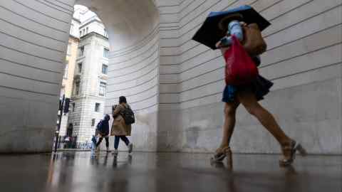 Commuters pass the Bank of England in the City of London
