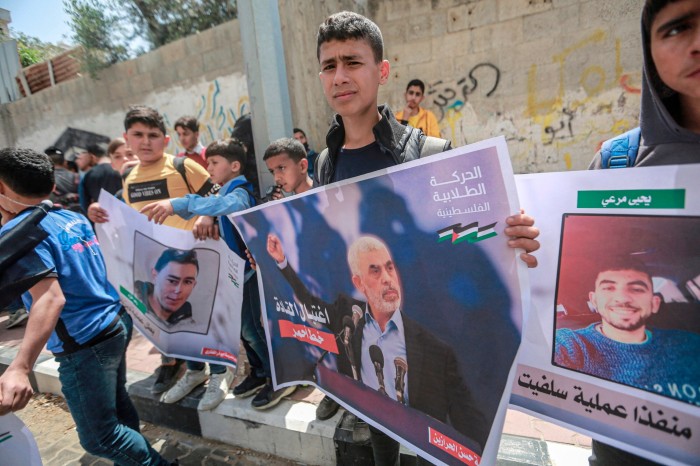Palestijnse studenten houden posters en borden vast tijdens een protest ter ondersteuning van Yahya Sinwar, de politieke leider van Hamas, voor zijn kantoor in Gaza-stad in mei 2022