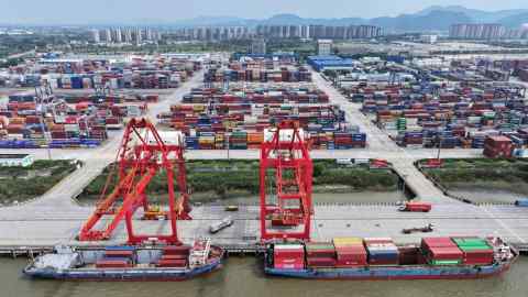 Containerschepen meren aan bij kranen in de haven van Nanjing in de oostelijke Chinese provincie Jiangsu