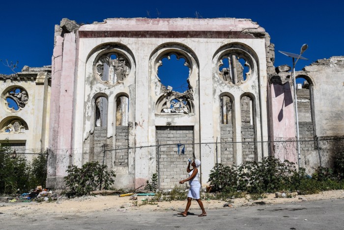 A woman walks past the ruins of Notre Dame Cathedral in Port-au-Prince