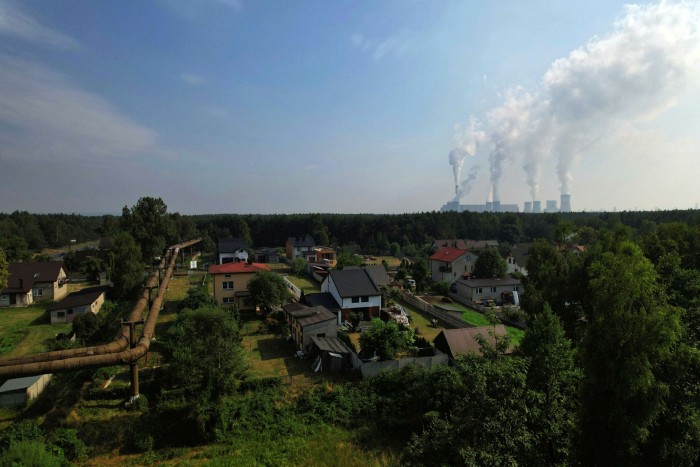 Pipework from a coal-fired power plant runs past houses in Belchatow, Poland, Even before the war in Ukraine, coal use was growing due to the post-pandemic economic recovery