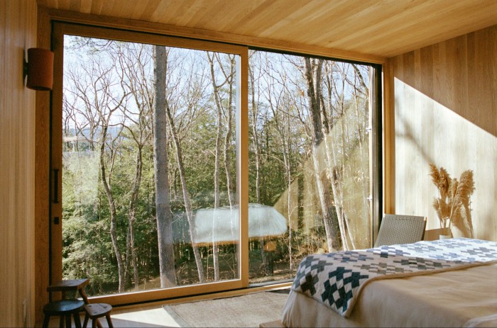 Ceiling-height windows offer views from one of the cabins at the Piaule Catskill hotel in New York State