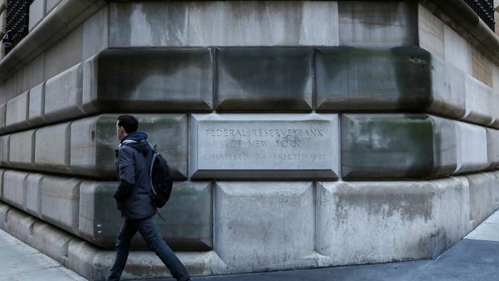 A man walks past the Federal Reserve Bank of New York