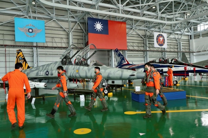 Taiwanese pilots of F-5 fighter jets walk in a hangar