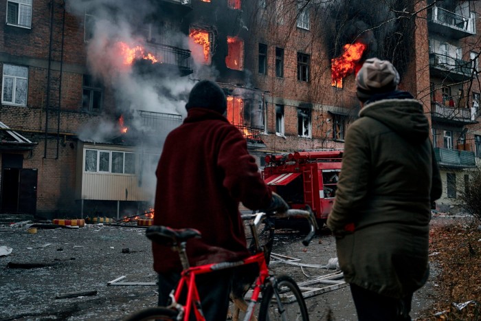 Residents outside a residential block set ablaze by Russian shelling in Bakhmut