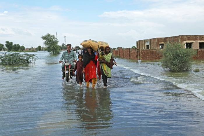 people wade through a flooded area