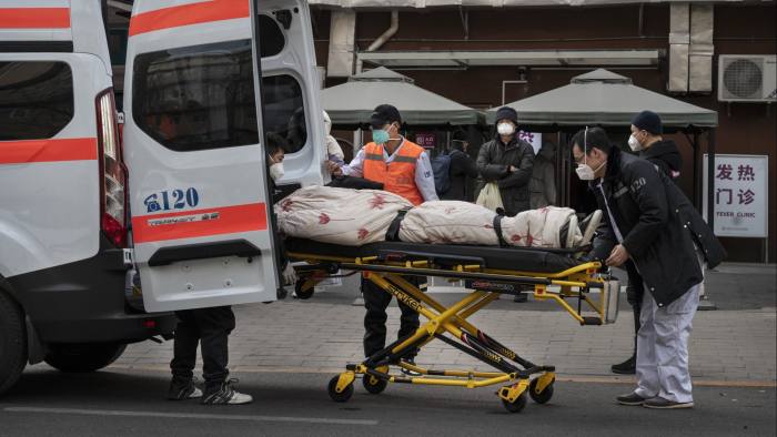 Ambulance drivers unload a patient outside a fever clinic in Beijing