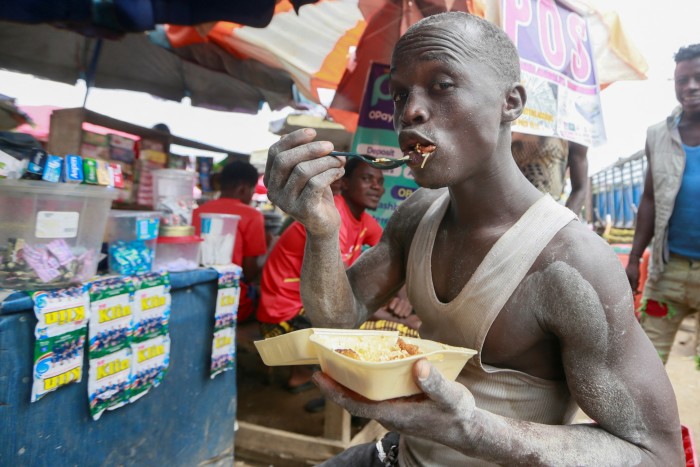 A man eats a breakfast of rice and plantain at a market in Abuja, Nigeria