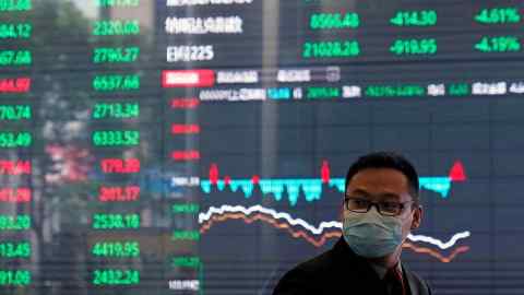 A man wearing a protective mask is seen inside the Shanghai Stock Exchange building