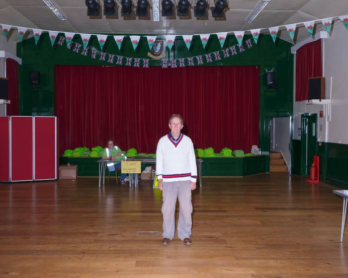 Bob Greenough, the director of Green Events, at the Victoria Hall, just before riders and runners arrive for registration. He is wearing a white V-necked jumper and trousers 