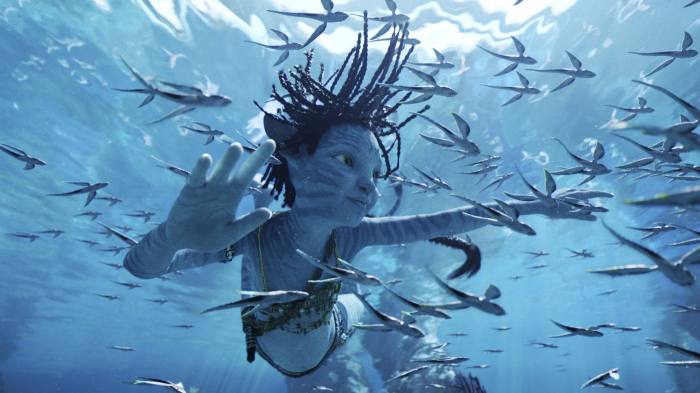 Plavo stvorenje pliva pod vodom, okruženo vanzemaljskim ribama